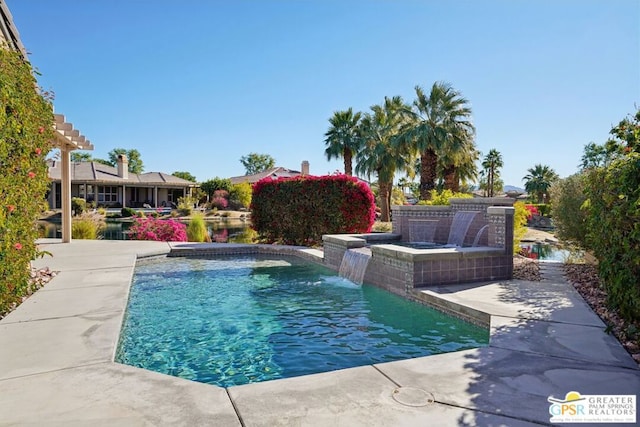 view of swimming pool with pool water feature and a jacuzzi