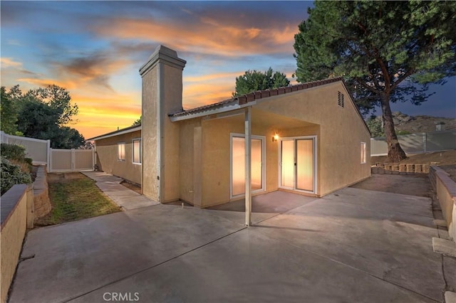 back house at dusk with a patio