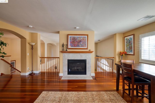 living room featuring a tile fireplace and wood-type flooring