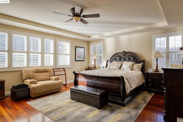 bedroom featuring dark hardwood / wood-style flooring, multiple windows, and ceiling fan