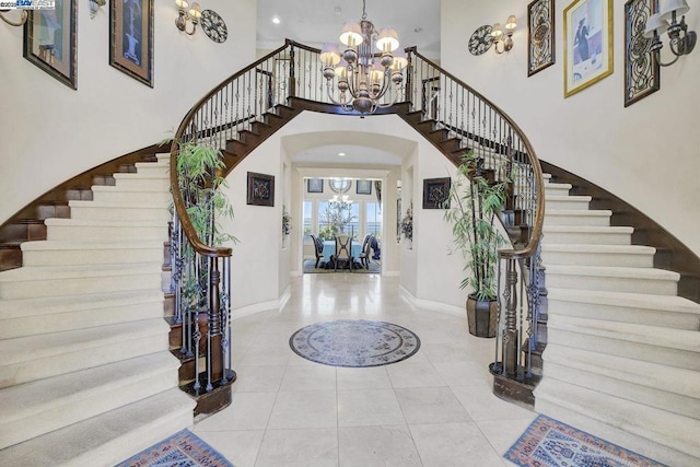 tiled foyer entrance featuring a high ceiling and an inviting chandelier