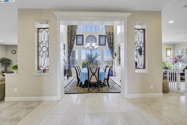 tiled dining room featuring a notable chandelier and a wealth of natural light