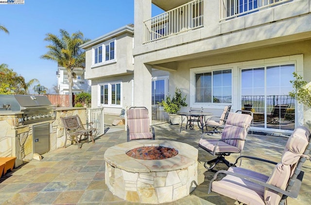 view of patio featuring exterior kitchen, a fire pit, and grilling area