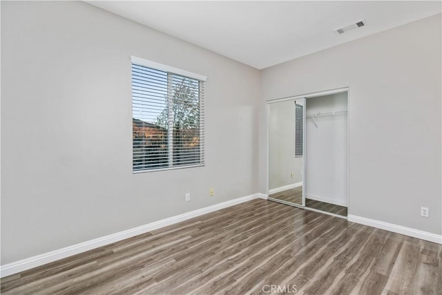 unfurnished bedroom with a closet and hardwood / wood-style floors