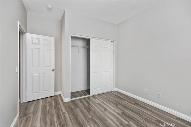 unfurnished bedroom featuring a closet and hardwood / wood-style floors