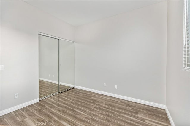 unfurnished bedroom with a closet and wood-type flooring