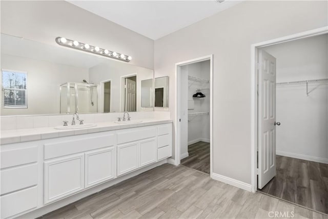 bathroom featuring vanity, wood-type flooring, and walk in shower