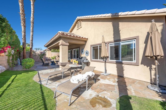 back of house featuring a patio and a lawn