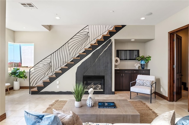 living room featuring visible vents, baseboards, stairway, recessed lighting, and a fireplace