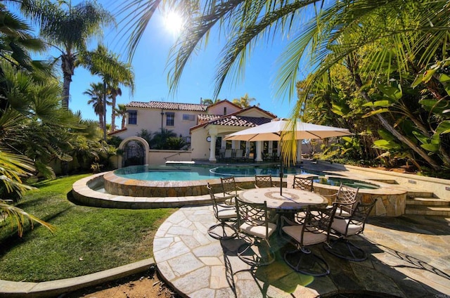 view of swimming pool featuring an in ground hot tub and a patio