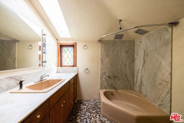 bathroom featuring shower / washtub combination, vanity, and a skylight