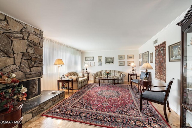 living room featuring light parquet floors and a stone fireplace