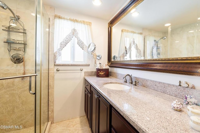 bathroom with tile patterned flooring, walk in shower, and vanity