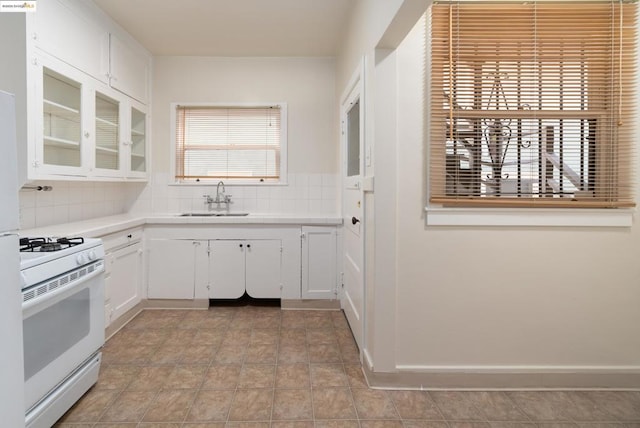 kitchen featuring sink, white cabinetry, gas range gas stove, and plenty of natural light