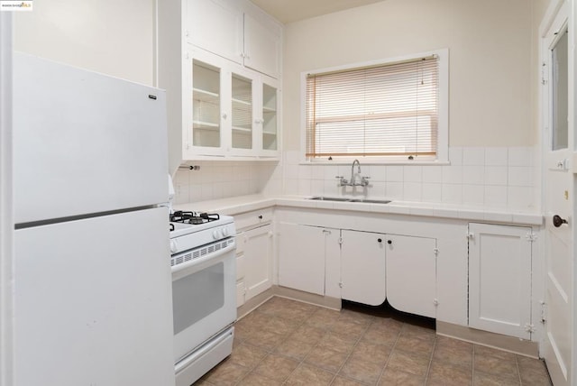 kitchen with white appliances, white cabinets, tile counters, decorative backsplash, and sink