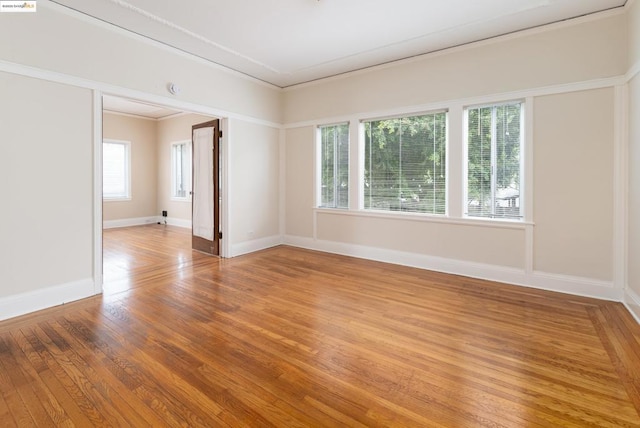 spare room featuring crown molding and hardwood / wood-style flooring