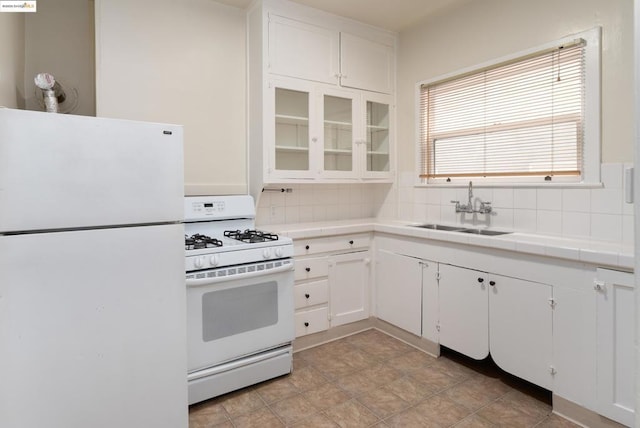 kitchen featuring white cabinetry, sink, tile countertops, and white appliances