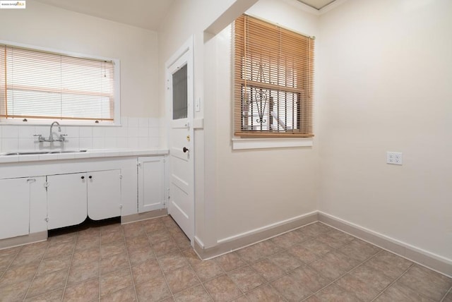 kitchen featuring decorative backsplash, sink, and white cabinets