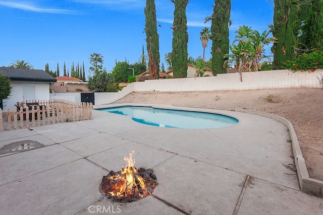 view of swimming pool with an outdoor fire pit and a patio