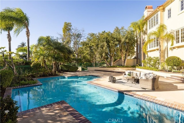 view of swimming pool with an outdoor living space and a patio area