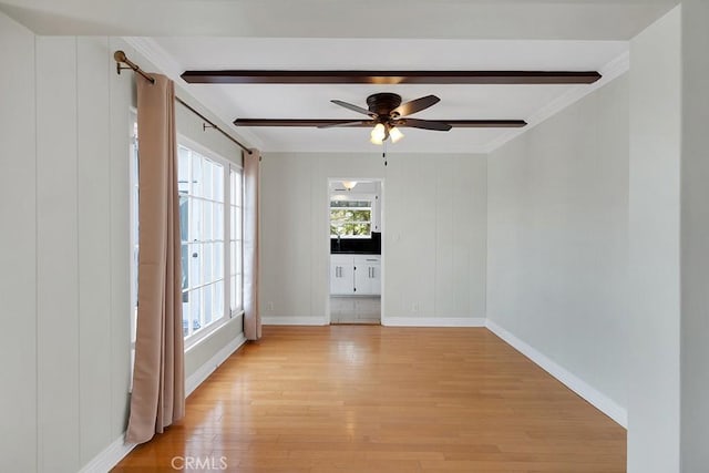 unfurnished room featuring ceiling fan, beam ceiling, light hardwood / wood-style floors, and crown molding