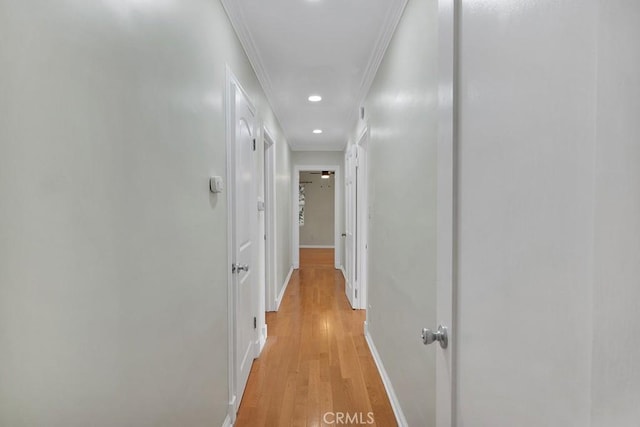 corridor with crown molding and light hardwood / wood-style floors