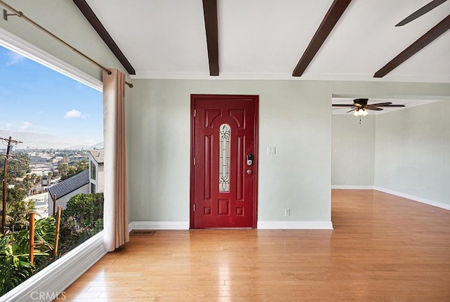 entrance foyer with light hardwood / wood-style floors, beam ceiling, and ceiling fan