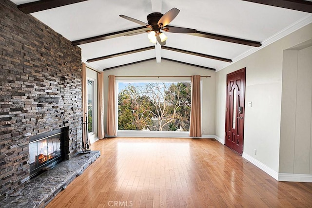 unfurnished living room with ceiling fan, light hardwood / wood-style floors, a fireplace, and vaulted ceiling with beams