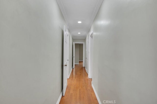 corridor featuring light wood-type flooring and crown molding