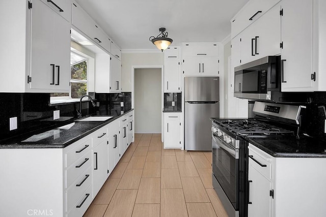 kitchen with decorative backsplash, sink, stainless steel appliances, and white cabinetry