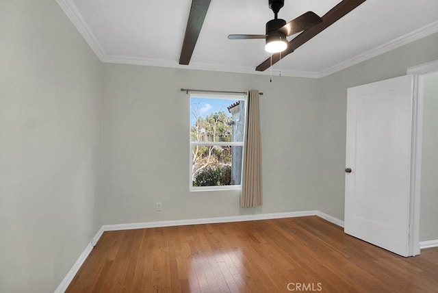 empty room with ceiling fan, wood-type flooring, crown molding, and beam ceiling