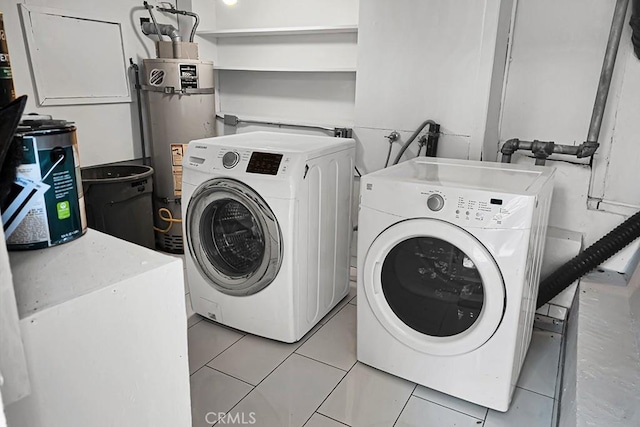 laundry room featuring light tile patterned floors, strapped water heater, and washing machine and clothes dryer