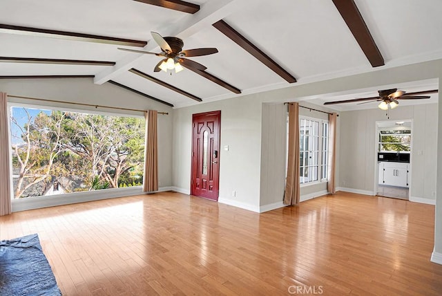 unfurnished living room with ceiling fan, a healthy amount of sunlight, lofted ceiling with beams, and light wood-type flooring