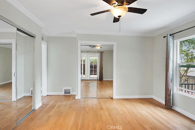 unfurnished room with light wood-type flooring, ceiling fan, crown molding, and french doors