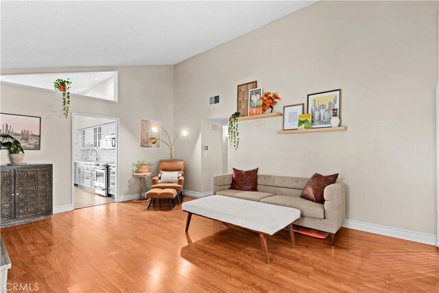 living room with wood-type flooring and vaulted ceiling