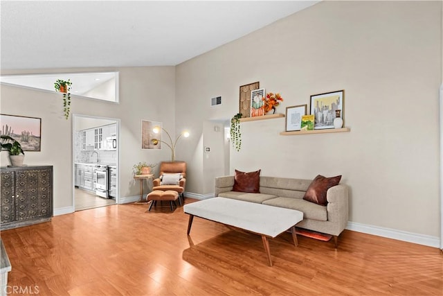 living room with hardwood / wood-style flooring and high vaulted ceiling