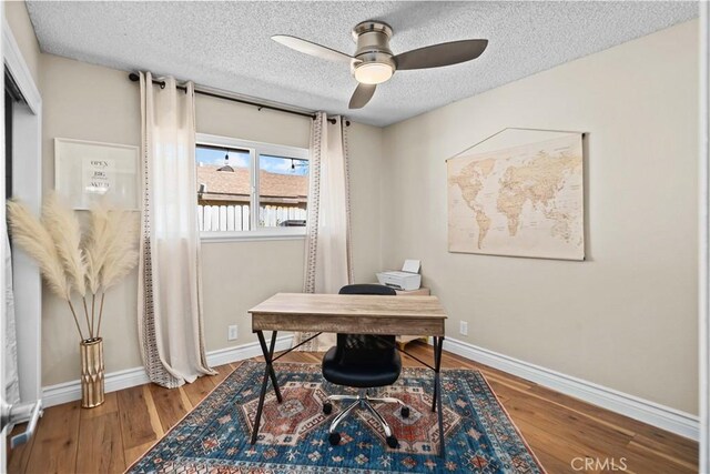 office space featuring ceiling fan, wood-type flooring, and a textured ceiling