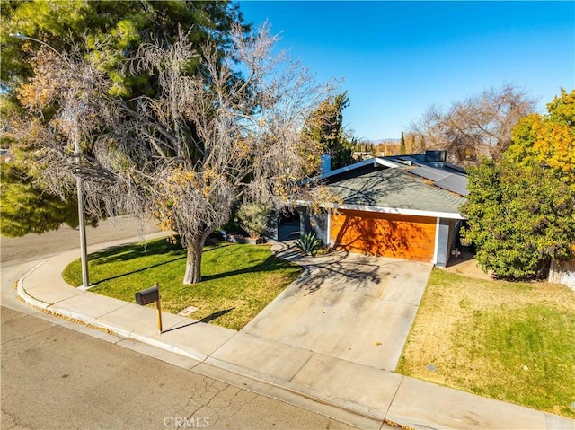 view of front of property featuring a front lawn and a garage