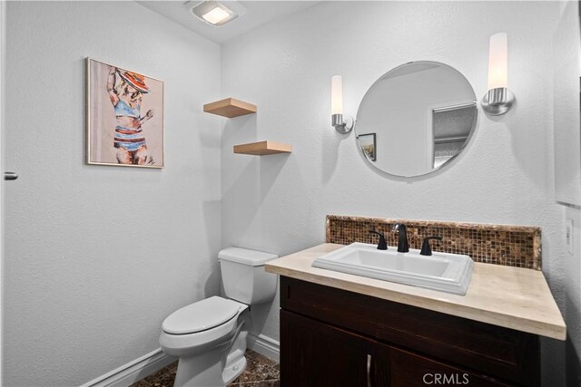 bathroom featuring decorative backsplash, toilet, and vanity