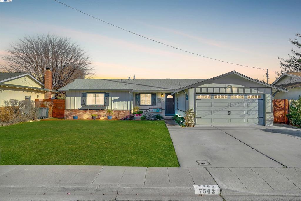 single story home featuring a yard and a garage