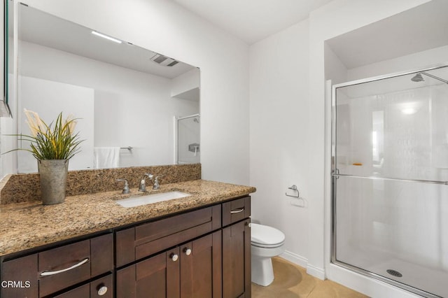 bathroom featuring vanity, toilet, a shower with shower door, and tile patterned flooring