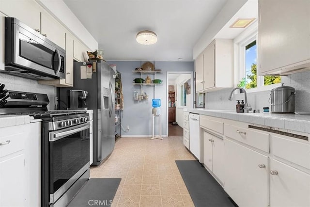 kitchen with sink, white cabinetry, backsplash, and appliances with stainless steel finishes