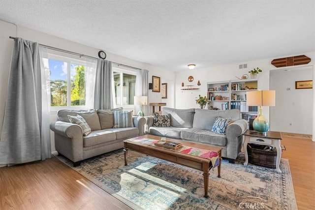 living room with wood-type flooring and a textured ceiling