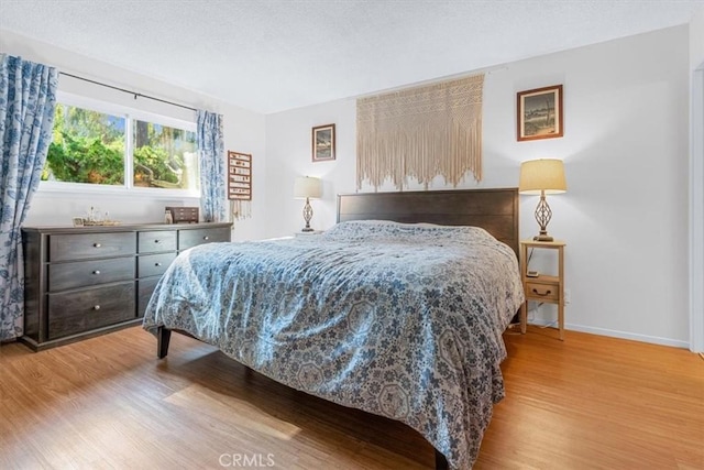 bedroom with a textured ceiling and light wood-type flooring