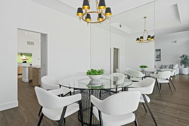 dining space with a towering ceiling, a tray ceiling, and a notable chandelier