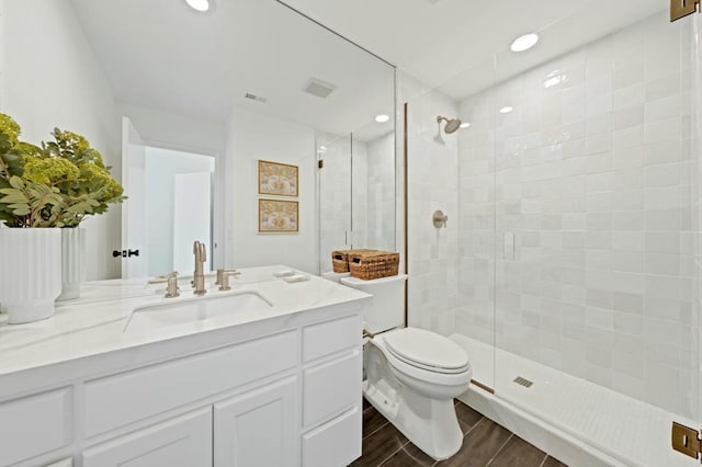 bathroom featuring toilet, an enclosed shower, and vanity