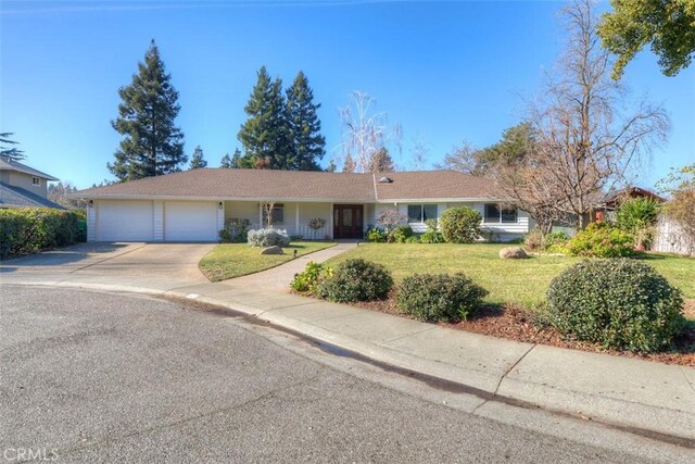 ranch-style house with an attached garage, concrete driveway, and a front yard