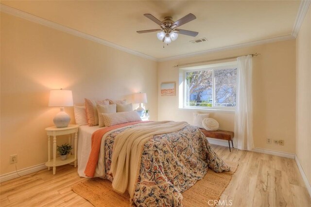 bedroom with visible vents, light wood finished floors, and crown molding