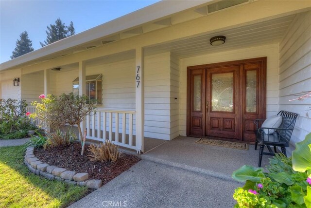 view of exterior entry with covered porch