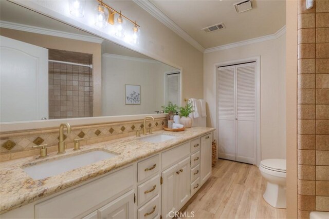 bathroom with visible vents, a sink, and wood finished floors
